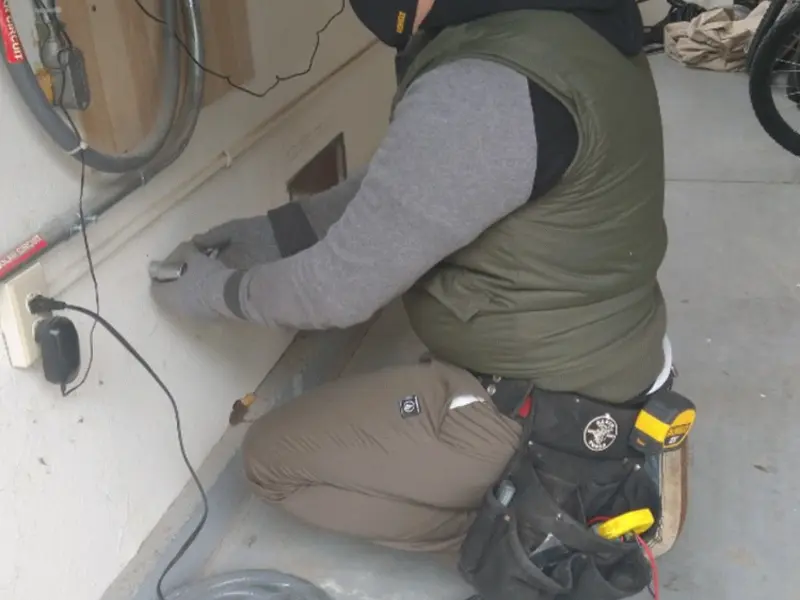 Electrician performing outlet wiring in a St. Joseph garage